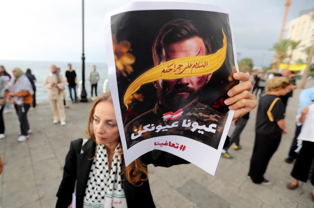 (250918) -- BEIRUT, Sept. 18, 2025 (Xinhua) -- A woman holds a sign showing support for the victims of the pager explosion on the first anniversary of the attack in Beirut, Lebanon, on Sept. 17, 2025. (Xinhua/Bilal Jawich)