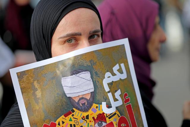 (250918) -- BEIRUT, Sept. 18, 2025 (Xinhua) -- A woman holds a sign showing support for the victims of the pager explosion on the first anniversary of the attack in Beirut, Lebanon, on Sept. 17, 2025. (Xinhua/Bilal Jawich)