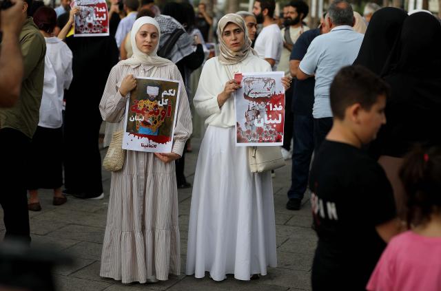 (250918) -- BEIRUT, Sept. 18, 2025 (Xinhua) -- People hold signs showing support for the victims of the pager explosion on the first anniversary of the attack in Beirut, Lebanon, on Sept. 17, 2025. (Xinhua/Bilal Jawich)