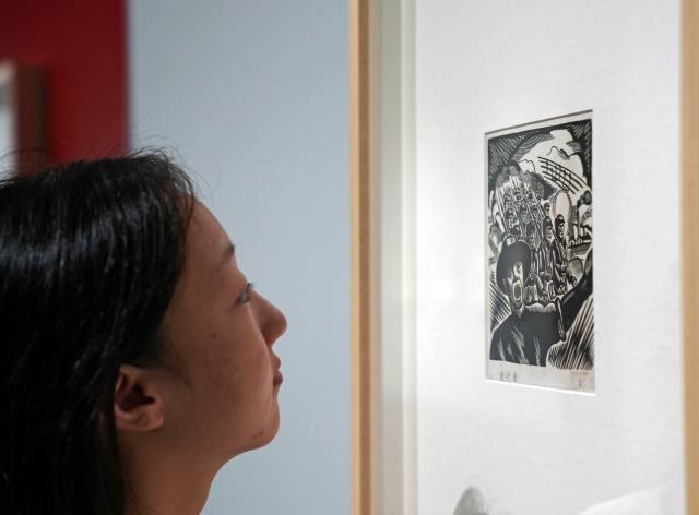 (250918) -- SHANGHAI, Sept. 18, 2025 (Xinhua) -- A visitor views a piece of work at a woodblock painting exhibition in commemoration of the 80th anniversary of the victory of the Chinese People's War of Resistance against Japanese Aggression and the World Anti-Fascist War in Shanghai, east China, Sept. 18, 2025. Kicking off Thursday at Shanghai Jiao Tong University, the exhibition showcases over 120 woodblock paintings. (Xinhua/Liu Ying)