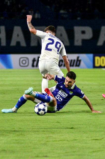 (250919) -- BANDUNG, Sept. 19, 2025 (Xinhua) -- Frans Putros (Bottom) of Persib Bandung vies with Diogo Costa of Lion City Sailors during the Pool G match between Persib Bandung of Indonesia and Lion City Sailors of Singapore at the AFC Champions League Two football match in Bandung, Indonesia, Sept. 18, 2025. (Photo by Septianjar Muharam/Xinhua)
