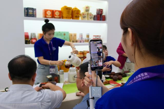 (250919) -- NANNING, Sept. 19, 2025 (Xinhua) -- A staff member promotes Liubao tea via live streaming at the Nanning International Convention and Exhibition Center in Nanning, capital of south China's Guangxi Zhuang Autonomous Region, Sept. 18, 2025. Liubao tea, a Chinese dark tea known for its strong, lingering fragrance and medicinal properties, boasts a history spanning over 1,500 years. It has attracted thousands of eyes with its presence at the ongoing 22nd China-ASEAN Expo.
   The traditional Liubao tea-making technique is also recognized as a UNESCO Intangible Cultural Heritage subproject. Named after Liubao Town in Wuzhou City, Guangxi, the tea thrives in this region, where mist-covered mountains and a favorable climate have long made it an ideal area for tea cultivation. (Xinhua/Hu Qiusi)