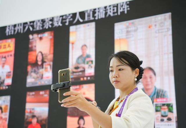(250919) -- NANNING, Sept. 19, 2025 (Xinhua) -- A staff member promotes Liubao tea via live streaming at the Nanning International Convention and Exhibition Center in Nanning, capital of south China's Guangxi Zhuang Autonomous Region, Sept. 18, 2025. Liubao tea, a Chinese dark tea known for its strong, lingering fragrance and medicinal properties, boasts a history spanning over 1,500 years. It has attracted thousands of eyes with its presence at the ongoing 22nd China-ASEAN Expo.
   The traditional Liubao tea-making technique is also recognized as a UNESCO Intangible Cultural Heritage subproject. Named after Liubao Town in Wuzhou City, Guangxi, the tea thrives in this region, where mist-covered mountains and a favorable climate have long made it an ideal area for tea cultivation. (Xinhua/Zhou Tinglu)