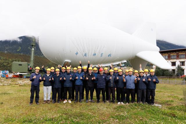 (250920) -- NYINGCHI, Sept. 20, 2025 (Xinhua) -- Some members of the "Jimu-1" tethered balloon atmospheric observation experiment team pose for a group photo in Lulang, Nyingchi, southwest China's Xizang Autonomous Region, Sept. 18, 2025.
  Chinese scientists recently carried out the "Jimu-1" tethered balloon atmospheric observation experiment in Lulang, Nyingchi, southwest China's Xizang Autonomous Region, which is expected to provide a new perspective for unraveling the mysteries of the Qinghai-Tibet Plateau ecosystem.
  The tethered balloon was equipped with 16 types of scientific payloads with a total weight of approximately 200 kilograms. It successfully ascended to an altitude of 5,500 meters. Through coordinated multi-payload observations, the experiment achieved a technological leap from single-point sampling to three-dimensional monitoring, according to the Aerospace Information Research Institute (AIR) of the Chinese Academy of Sciences, the major developer of the tethered balloon. (Xinhua/Jin Liwang)