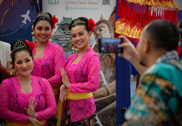 (250921) -- VANCOUVER, Sept. 21, 2025 (Xinhua) -- A visitor takes photos of dancers during the Vancouver International Travel Expo in Vancouver, British Columbia, Canada, Sept. 20, 2025. The annual event was held at the Vancouver Convention Center on Saturday, featuring about 200 exhibitors showcasing travel ideas and destinations from around the world. (Photo by Liang Sen/Xinhua)