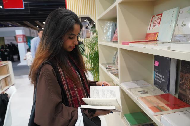 (251002) -- RIYADH, Oct. 2, 2025 (Xinhua) -- A woman reads a book at the China Pavilion of the Riyadh International Book Fair 2025 in Riyadh, Saudi Arabia, Oct. 2, 2025. The book fair opened here on Thursday, bringing together over 2,000 local and international publishing houses from more than 25 countries, along with a range of cultural institutions. (Xinhua/Luo Chen)