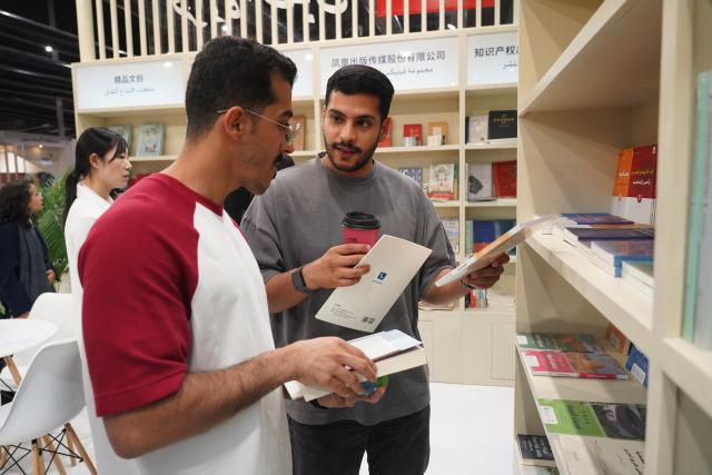 (251002) -- RIYADH, Oct. 2, 2025 (Xinhua) -- Two men talk at the China Pavilion of the Riyadh International Book Fair 2025 in Riyadh, Saudi Arabia, Oct. 2, 2025. The book fair opened here on Thursday, bringing together over 2,000 local and international publishing houses from more than 25 countries, along with a range of cultural institutions. (Xinhua/Luo Chen)