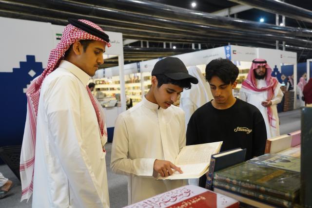 (251002) -- RIYADH, Oct. 2, 2025 (Xinhua) -- People read a book at the Riyadh International Book Fair 2025 in Riyadh, Saudi Arabia, Oct. 2, 2025. The book fair opened here on Thursday, bringing together over 2,000 local and international publishing houses from more than 25 countries, along with a range of cultural institutions. (Xinhua/Luo Chen)