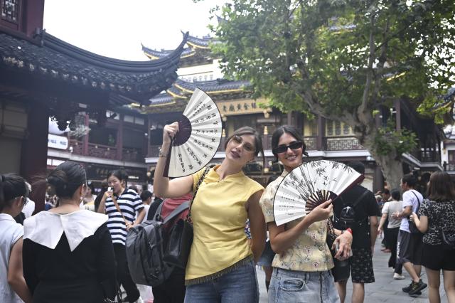 (251004) -- SHANGHAI, Oct. 4, 2025 (Xinhua) -- Shuanet (L) and Lolita from Russia pose for photos at Yuyuan Garden Mall in east China's Shanghai, Oct. 3, 2025. The eastern Chinese megacity of Shanghai received a whopping 4.1 million overseas visitors from January to August this year.
  The latest tourism boom in the city has resulted from a series of policies that provide greater convenience for international tourists entering China. As one of the country's most famous tourist cities, Shanghai is usually among the first places affected by new policies for the sector.
    According to Shanghai General Station of Immigration Inspection, the airport ports in Shanghai are expected to handle 883,000 inbound and outbound passengers during the National Day holiday from Oct. 1 to 8, which is a daily average of 116,000 passengers, a 22.3 percent increase year on year. (Xinhua/Chen Haoming)