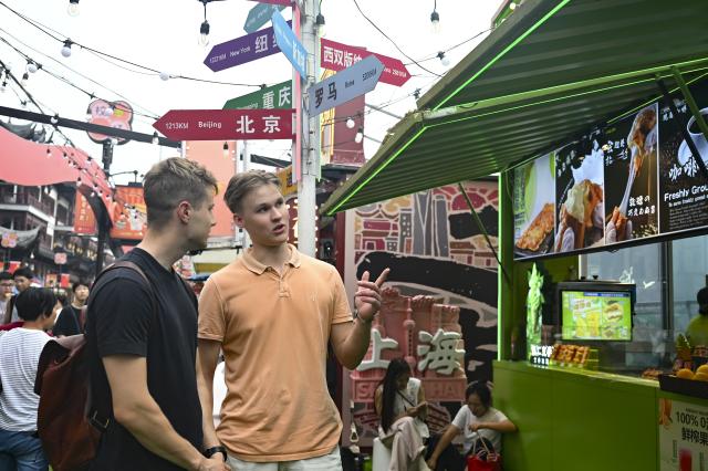(251004) -- SHANGHAI, Oct. 4, 2025 (Xinhua) -- Perttu Nevala (L) and Emil Halomen from Finland visit Yuyuan Garden Mall in east China's Shanghai, Oct. 3, 2025. The eastern Chinese megacity of Shanghai received a whopping 4.1 million overseas visitors from January to August this year.
  The latest tourism boom in the city has resulted from a series of policies that provide greater convenience for international tourists entering China. As one of the country's most famous tourist cities, Shanghai is usually among the first places affected by new policies for the sector.
    According to Shanghai General Station of Immigration Inspection, the airport ports in Shanghai are expected to handle 883,000 inbound and outbound passengers during the National Day holiday from Oct. 1 to 8, which is a daily average of 116,000 passengers, a 22.3 percent increase year on year. (Xinhua/Chen Haoming)