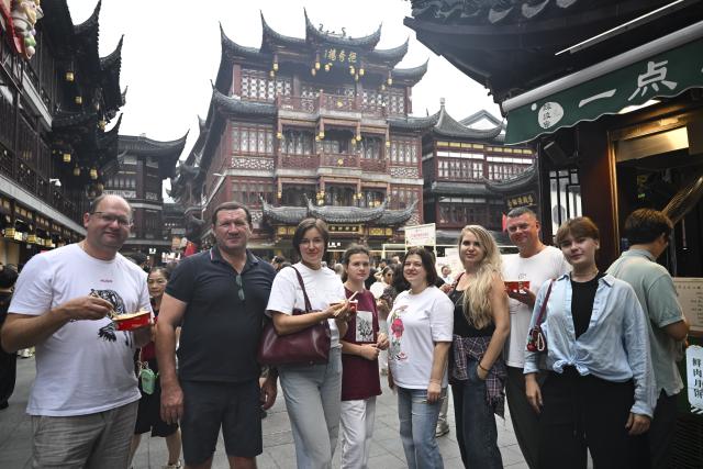(251004) -- SHANGHAI, Oct. 4, 2025 (Xinhua) -- Tourists from Russia pose for photos at Yuyuan Garden Mall in east China's Shanghai, Oct. 3, 2025. The eastern Chinese megacity of Shanghai received a whopping 4.1 million overseas visitors from January to August this year.
  The latest tourism boom in the city has resulted from a series of policies that provide greater convenience for international tourists entering China. As one of the country's most famous tourist cities, Shanghai is usually among the first places affected by new policies for the sector.
    According to Shanghai General Station of Immigration Inspection, the airport ports in Shanghai are expected to handle 883,000 inbound and outbound passengers during the National Day holiday from Oct. 1 to 8, which is a daily average of 116,000 passengers, a 22.3 percent increase year on year. (Xinhua/Chen Haoming)