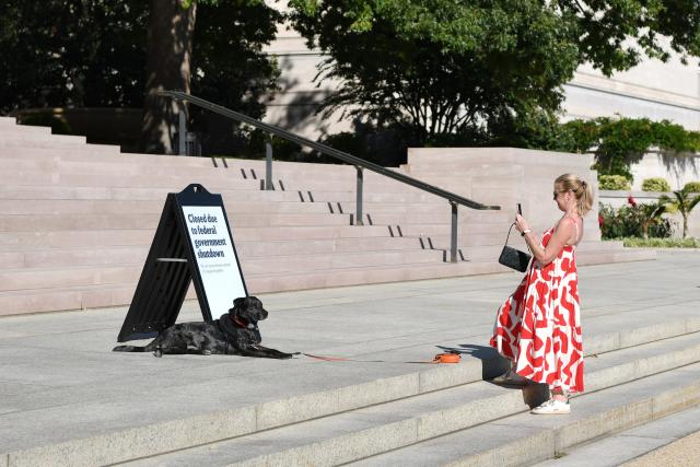 (251006) -- WASHINGTON, Oct. 6, 2025 (Xinhua) -- A woman takes photos of her dog next to a notice of closure of the National Gallery of Art in Washington, D.C., the United States, Oct. 5, 2025. As the U.S. federal government entered a shutdown -- the first time in nearly seven years -- the confrontation between President Donald Trump's administration and the Democratic Party has further escalated.
   The Trump administration has cut funding and programs in Democratic-led states and sought to dismantle federal agencies led by Democrats. Meanwhile, Democrats have shown a rare sense of unity, hoping to reverse declining approval ratings through the fight.
   This new round of partisan conflict over the government shutdown is markedly different from previous ones, characterized by greater hostility and malice that has pushed partisan strife to new heights. It highlights the deepening political polarization in the United States while inflicting greater harm on the American people. (Xinhua/Li Rui)