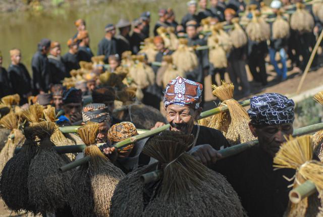 (251006) -- SUKABUMI, Oct. 6, 2025 (Xinhua) -- This photo taken on Oct. 5, 2025 shows people carrying harvested paddy during the Seren Taun festival in Sukabumi regency of West Java, Indonesia. Seren Taun is a traditional festival for local people to celebrate paddy harvest and express gratitude. (Photo by Rangga Firmansyah/Xinhua)