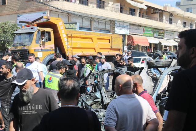(251006) -- NABATIEH(LEBANON), Oct. 6, 2025 (Xinhua) -- People inspect the wreckage of a vehicle struck by missiles fired by Israeli forces in Nabatieh, southern Lebanon, on Oct. 6, 2025. An Israeli airstrike on southern Lebanon killed two people and wounded another on Monday, the state-run National News Agency (NNA) reported. The NNA said Israeli forces fired two guided missiles at a vehicle in Nabatieh, killing Hassan Atwi and his wife, Zeinab Raslan, whom it described as civilians. The couple had lost their two children earlier in the war with Israel. (Photo by Taher Abu Hamdan/Xinhua)