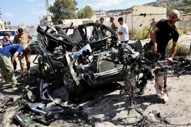 (251006) -- NABATIEH(LEBANON), Oct. 6, 2025 (Xinhua) -- People inspect the wreckage of a vehicle struck by missiles fired by Israeli forces in Nabatieh, southern Lebanon, on Oct. 6, 2025. An Israeli airstrike on southern Lebanon killed two people and wounded another on Monday, the state-run National News Agency (NNA) reported. The NNA said Israeli forces fired two guided missiles at a vehicle in Nabatieh, killing Hassan Atwi and his wife, Zeinab Raslan, whom it described as civilians. The couple had lost their two children earlier in the war with Israel. (Photo by Taher Abu Hamdan/Xinhua)