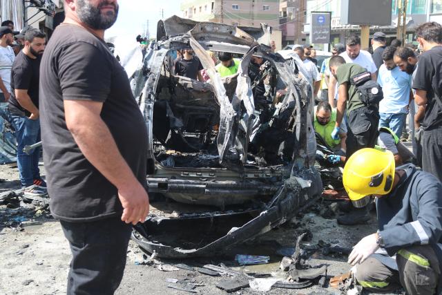 (251006) -- NABATIEH(LEBANON), Oct. 6, 2025 (Xinhua) -- People inspect the wreckage of a vehicle struck by missiles fired by Israeli forces in Nabatieh, southern Lebanon, on Oct. 6, 2025. An Israeli airstrike on southern Lebanon killed two people and wounded another on Monday, the state-run National News Agency (NNA) reported. The NNA said Israeli forces fired two guided missiles at a vehicle in Nabatieh, killing Hassan Atwi and his wife, Zeinab Raslan, whom it described as civilians. The couple had lost their two children earlier in the war with Israel. (Photo by Taher Abu Hamdan/Xinhua)