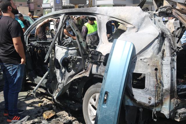 (251006) -- NABATIEH(LEBANON), Oct. 6, 2025 (Xinhua) -- People inspect the wreckage of a vehicle struck by missiles fired by Israeli forces in Nabatieh, southern Lebanon, on Oct. 6, 2025. An Israeli airstrike on southern Lebanon killed two people and wounded another on Monday, the state-run National News Agency (NNA) reported. The NNA said Israeli forces fired two guided missiles at a vehicle in Nabatieh, killing Hassan Atwi and his wife, Zeinab Raslan, whom it described as civilians. The couple had lost their two children earlier in the war with Israel. (Photo by Taher Abu Hamdan/Xinhua)