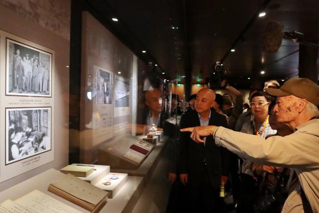 (251009) -- BEIJING, Oct. 9, 2025 (Xinhua) -- Chuang Ling (1st R), the son of Chuang Yan, former vice curator of the Palace Museum in Taipei, introduces the exhibits at an exhibition commemorating the miraculous evacuation of the Palace Museum's collection during Chinese People's War of Resistance against Japanese Aggression more than 80 years ago, in Beijing, capital of China, Sept. 30, 2025. TO GO WITH "Feature: Centennial Palace Museum bridges Chinese across Taiwan Strait" (Xinhua)