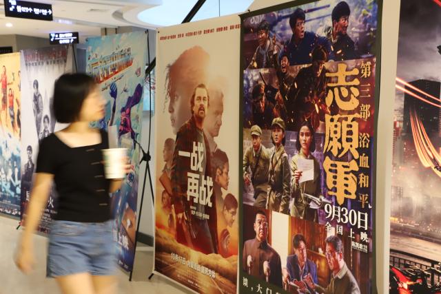 (251010) -- BEIJING, Oct. 10, 2025 (Xinhua) -- A woman walks past the film posters at a cineplex in Xiamen, southeast China's Fujian Province, Oct. 8, 2025.
  From Oct. 1 to 8, the box office of the 2025 National Day film season in China has reached 1.835 billion yuan (about 257.4 million U.S. dollars), with 50.07 million people stepping into the cinemas, according to the data released by China Film Administration on Thursday. (Photo by Ze Demeng/Xinhua)