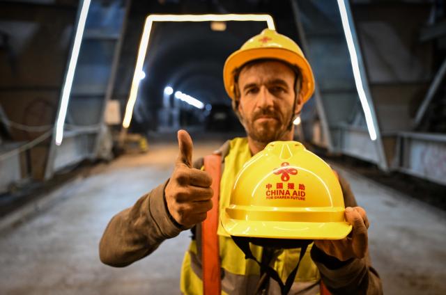 (251011) -- DUSHANBE, Oct. 11, 2025 (Xinhua) -- A Tajik worker poses for photos with a helmet at the construction site of the second-phase section of the China-Tajikistan Highway near Kalai Khumb, Tajikistan, on Sept. 11, 2025. The China-Tajikistan Highway -- also known as the Pamir Highway -- was first built in the 1940s. Stretching more than 1,000 km from Dushanbe to Karasu on the China-Tajikistan border, it is vital for Tajikistan's transport and external links.
   TO GO WITH "Feature: China-Tajikistan Highway a lifeline on the Pamirs" (Xinhua/Li Renzi)