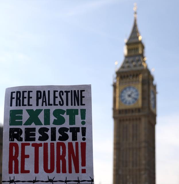 (251012) -- LONDON, Oct. 12, 2025 (Xinhua) -- A placard held by a protester is pictured near the Big Ben in London, Britain, Oct. 11, 2025. Tens of thousands of people took to the street here on Saturday in support of Palestine. (Xinhua/Li Ying)