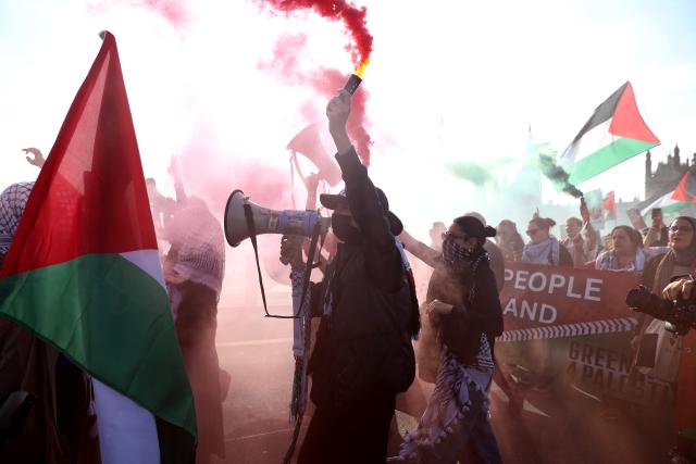 (251012) -- LONDON, Oct. 12, 2025 (Xinhua) -- A protester sets off colored smoke near the Big Ben in London, Britain, Oct. 11, 2025. Tens of thousands of people took to the street here on Saturday in support of Palestine. (Xinhua/Li Ying)