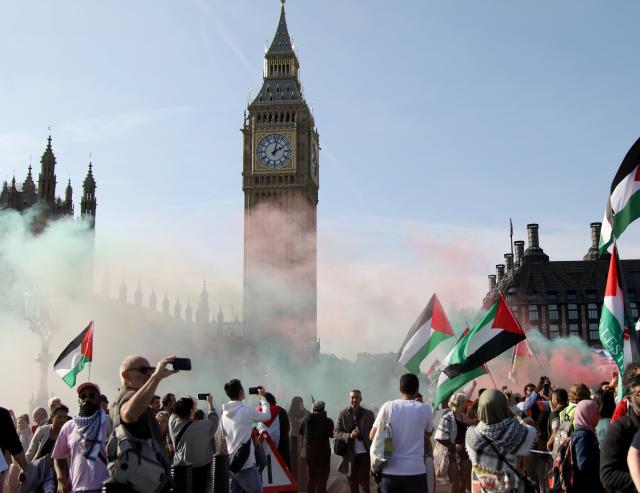 (251012) -- LONDON, Oct. 12, 2025 (Xinhua) -- Protesters set off colored smoke near the Big Ben in London, Britain, Oct. 11, 2025. Tens of thousands of people took to the street here on Saturday in support of Palestine. (Xinhua/Li Ying)
