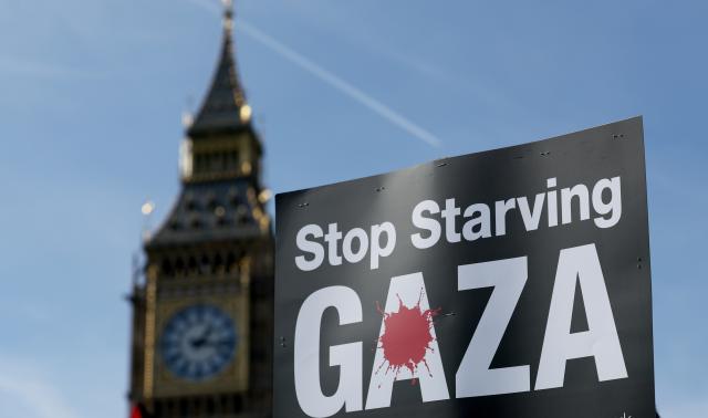 (251012) -- LONDON, Oct. 12, 2025 (Xinhua) -- A placard held by a protester is pictured near the Big Ben in London, Britain, Oct. 11, 2025. Tens of thousands of people took to the street here on Saturday in support of Palestine. (Xinhua/Li Ying)