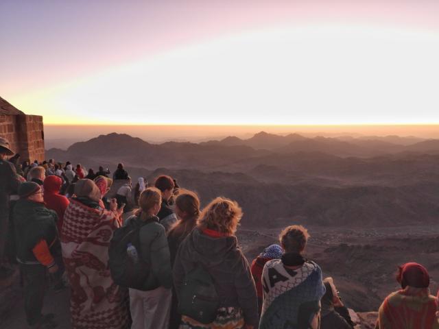 (251012) -- SINAI PENINSULA, Oct. 12, 2025 (Xinhua) -- Tourists view the scenery at sunrise from Mount Sinai in the Sinai Peninsula, Egypt, Oct. 11, 2025. (Photo by Liu Minhao/Xinhua)