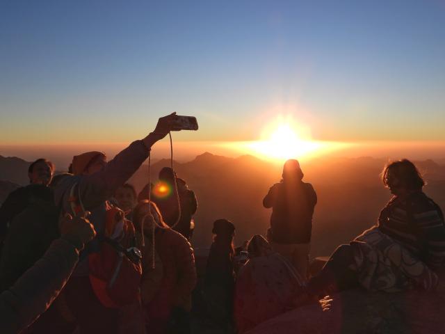(251012) -- SINAI PENINSULA, Oct. 12, 2025 (Xinhua) -- Tourists view the scenery at sunrise from Mount Sinai in the Sinai Peninsula, Egypt, Oct. 11, 2025. (Photo by Liu Minhao/Xinhua)