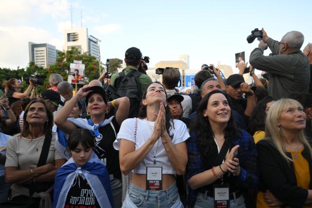 (251013) -- TEL AVIV, Oct. 13, 2025 (Xinhua) -- People watch live broadcasting of the release of hostages on a square in Tel Aviv, Israel, on Oct. 13, 2025. Hamas on Monday morning began releasing the first batch of hostages who had been held in Gaza for more than two years, as part of a major prisoner swap under a newly implemented ceasefire, Israel's state-owned Kan TV reported. (Photo by Jamal Awad/Xinhua)