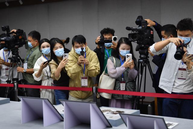 (251013) -- CHANGSHA, Oct. 13, 2025 (Xinhua) -- Journalists take images of the Zidanku Silk Manuscripts on display at the Hunan Museum in Changsha, capital of central China's Hunan Province, Oct. 13, 2025.
  Two volumes of Chinese silk manuscripts dating back about 2,300 years have been returned to central China, 79 years after they were smuggled out of the country, through cooperation between Chinese and the U.S. cultural institutions.
  The second and third volumes of the Zidanku Silk Manuscripts -- precious cultural artifacts dating back to the Warring States Period (475-221 B.C.) -- were on Monday officially repatriated to Hunan Province. They will be permanently archived in the Hunan Museum in Changsha, the provincial capital.
  The manuscripts, which were unearthed from a Chu-state tomb by tomb raiders at the Zidanku site in Changsha in 1942, consist of three volumes: "Sishi Ling," "Wuxing Ling" and "Gongshou Zhan." They are a systematic record of astronomy, calendars, cosmology and military divination from China's pre-Qin period. The silk manuscripts are the earliest examples of silk text discovered to date and the oldest classical Chinese book in the true sense. They were smuggled out of China in 1946.
  At the accession ceremony of the Zidanku Silk Manuscripts (Volumes II and III) on Monday, National Cultural Heritage Administration (NCHA) head Rao Quan said that the return of the manuscripts is a significant achievement of years of Sino-U.S. cultural and museum cooperation, and an example for international cooperation on artifact restitution.
  Through Sino-U.S. cooperation on the return of cultural property, the "Wuxing Ling" and "Gongshou Zhan" volumes were returned to China by the Smithsonian Institution's National Museum of Asian Art this year, arriving in Beijing on May 18. (Xinhua/Chen Zhenhai)