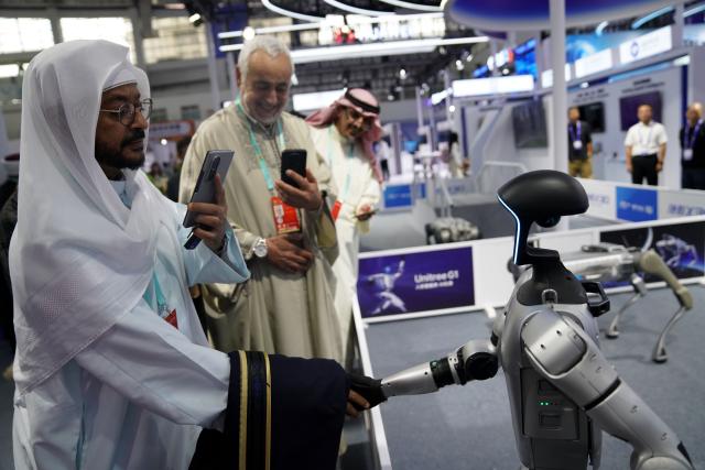 (251013) -- BEIJING, Oct. 13, 2025 (Xinhua) -- A visitor shakes hands with a humanoid robot at the seventh China-Arab States Expo in Yinchuan, northwest China's Ningxia Hui Autonomous Region, Aug. 28, 2025. (Xinhua/Zhao Yusi)