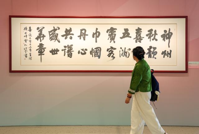 (251013) -- BEIJING, Oct. 13, 2025 (Xinhua) -- A woman views an exhibit during "Heritage Blossoms, Women Shine", a special exhibition celebrating the Global Leaders' Meeting on Women in Beijing, capital of China, Oct. 13, 2025. The Global Leaders' Meeting on Women was held in Beijing on Monday. (Xinhua/Liang Xu)