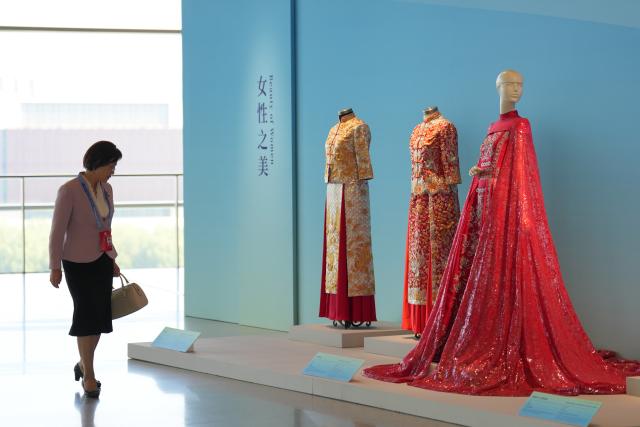 (251013) -- BEIJING, Oct. 13, 2025 (Xinhua) -- A woman visits "Heritage Blossoms, Women Shine", a special exhibition celebrating the Global Leaders' Meeting on Women in Beijing, capital of China, Oct. 13, 2025. The Global Leaders' Meeting on Women was held in Beijing on Monday. (Xinhua/Xu Bingjie)