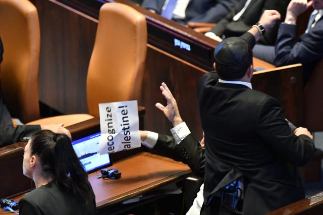 (251013) -- JERUSALEM, Oct. 13, 2025 (Xinhua) -- An Israeli Knesset member displays a sign calling for the recognition of Palestine during Trump's speech in Israeli parliament, the Knesset, in Jerusalem on Oct. 13, 2025. U.S. President Donald Trump addressed the Israeli parliament, the Knesset, on Monday during a brief visit as the Israel-Hamas ceasefire entered its fourth day, hailing an "end" to Israel's two-year war in Gaza. Trump's speech was briefly interrupted when a Knesset member displayed a sign calling for the recognition of Palestine. (JINI via Xinhua)