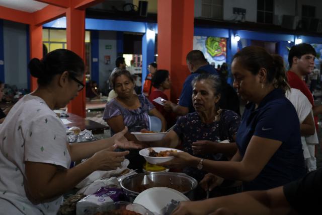 (251013) -- POZA RICA(MEXICO), Oct. 13, 2025 (Xinhua) -- People affected by the heavy rain receive food at a shelter in the city of Poza Rica, Veracruz state, Mexico, Oct. 12, 2025. At least 64 people have died and dozens remain missing after days of torrential rains and flooding that hit central and eastern Mexico last week, authorities said Monday. (Photo by Francisco Canedo/Xinhua)