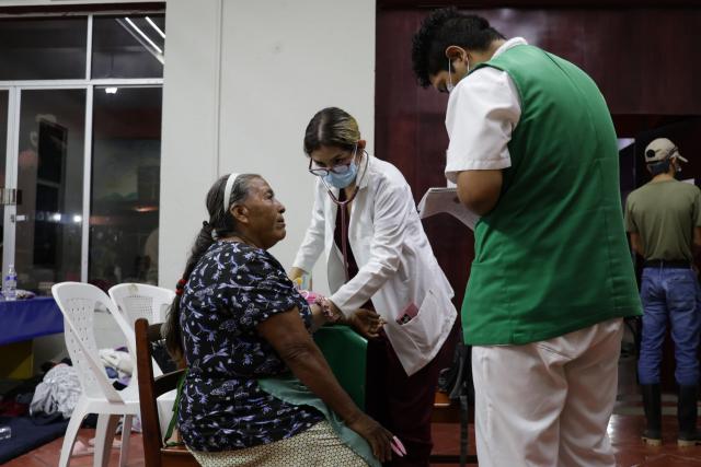 (251013) -- POZA RICA(MEXICO), Oct. 13, 2025 (Xinhua) -- A woman receives medical treatment at a shelter for flood victims in the city of Poza Rica, Veracruz state, Mexico, Oct. 12, 2025. At least 64 people have died and dozens remain missing after days of torrential rains and flooding that hit central and eastern Mexico last week, authorities said Monday. (Photo by Francisco Canedo/Xinhua)