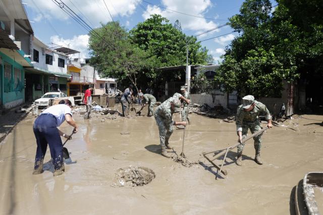 (251013) -- POZA RICA(MEXICO), Oct. 13, 2025 (Xinhua) -- Mexican soldiers help to clean a street affected by the heavy rain in the city of Poza Rica, Veracruz state, Mexico, Oct. 12, 2025. At least 64 people have died and dozens remain missing after days of torrential rains and flooding that hit central and eastern Mexico last week, authorities said Monday. (Photo by Francisco Canedo/Xinhua)