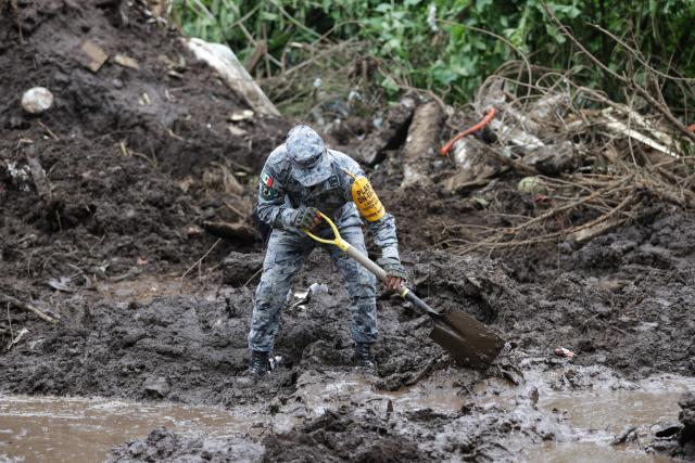 (251013) -- HUAUCHINANGO(MEXICO), Oct. 13, 2025 (Xinhua) -- This photo taken on Oct. 13, 2025 shows a rescue worker conducts a search in a landslide caused by the heavy rain in Huauchinango, Puebla state, Mexico. At least 64 people have died and dozens remain missing after days of torrential rains and flooding that hit central and eastern Mexico last week, authorities said Monday. (Photo by Francisco Canedo/Xinhua)