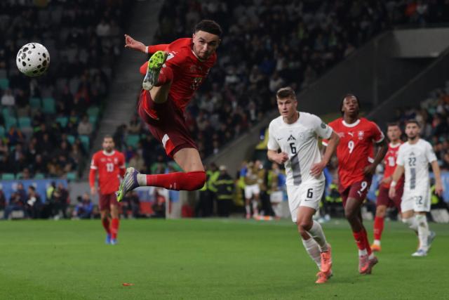 (251014) -- LJUBLJANA, Oct. 14, 2025 (Xinhua) -- Ruben Vargas (top) of Switzerland vies for the ball during the World Cup 2026 European Qualifiers Group B football match between Slovenia and Switzerland in Ljubljana, Slovenia, Oct. 13, 2025. (Photo by Zeljko Stevanic/Xinhua)