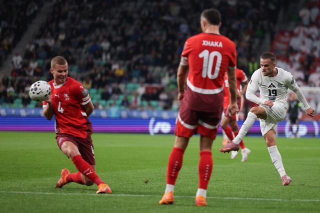 (251014) -- LJUBLJANA, Oct. 14, 2025 (Xinhua) -- Tomi Horvat (R) of Slovenia shoots during the World Cup 2026 European Qualifiers Group B football match between Slovenia and Switzerland in Ljubljana, Slovenia, Oct. 13, 2025. (Photo by Zeljko Stevanic/Xinhua)