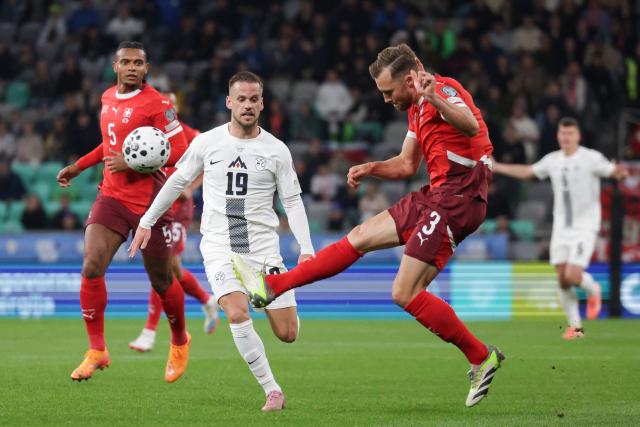 (251014) -- LJUBLJANA, Oct. 14, 2025 (Xinhua) -- Silvan Widmer (R) of Switzerland competes during the World Cup 2026 European Qualifiers Group B football match between Slovenia and Switzerland in Ljubljana, Slovenia, Oct. 13, 2025. (Photo by Zeljko Stevanic/Xinhua)
