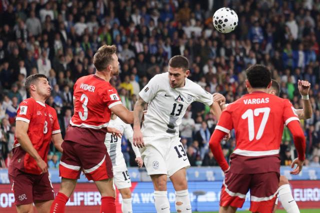 (251014) -- LJUBLJANA, Oct. 14, 2025 (Xinhua) -- Erik Janza (C) of Slovenia competes for a header with Silvan Widmer of Switzerland (front 2nd L) during the World Cup 2026 European Qualifiers Group B football match between Slovenia and Switzerland in Ljubljana, Slovenia, Oct. 13, 2025. (Photo by Zeljko Stevanic/Xinhua)