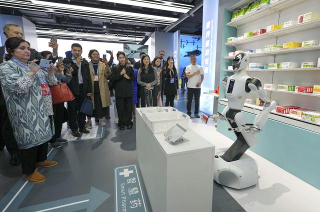(251014) -- BEIJING, Oct. 14, 2025 (Xinhua) -- Representatives, who are in Beijing for the Global Leaders' Meeting on Women, watch a robot fetching medicine at the Beijing World of Robots in Beijing, capital of China, Oct. 14, 2025. (Xinhua/Xue Yuge)