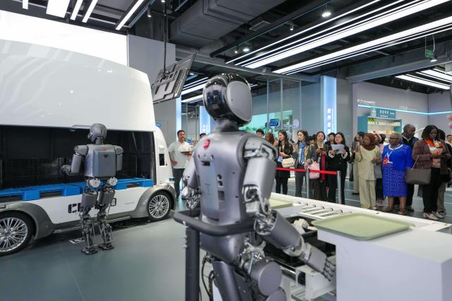 (251014) -- BEIJING, Oct. 14, 2025 (Xinhua) -- Representatives, who are in Beijing for the Global Leaders' Meeting on Women, watch the demonstration of a robot at the Beijing World of Robots in Beijing, capital of China, Oct. 14, 2025. (Xinhua/Xue Yuge)