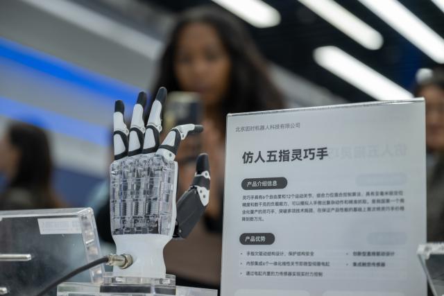 (251014) -- BEIJING, Oct. 14, 2025 (Xinhua) -- Representatives, who are in Beijing for the Global Leaders' Meeting on Women, learn about a robotic hand at the Beijing World of Robots in Beijing, capital of China, Oct. 14, 2025. (Xinhua/Du Zixuan)