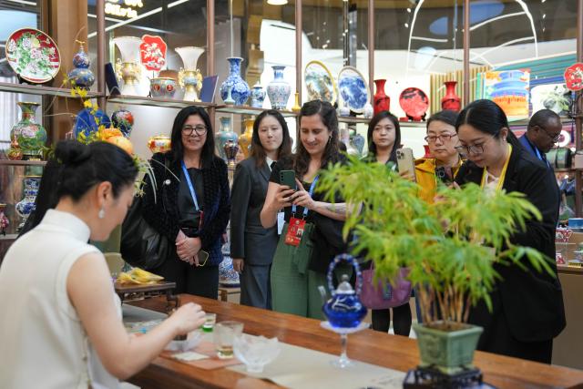 (251014) -- BEIJING, Oct. 14, 2025 (Xinhua) -- Representatives, who are in Beijing for the Global Leaders' Meeting on Women, watch a tea art display while visiting the Silk Street building in Beijing, capital of China, Oct. 14, 2025. (Xinhua/Xu Bingjie)