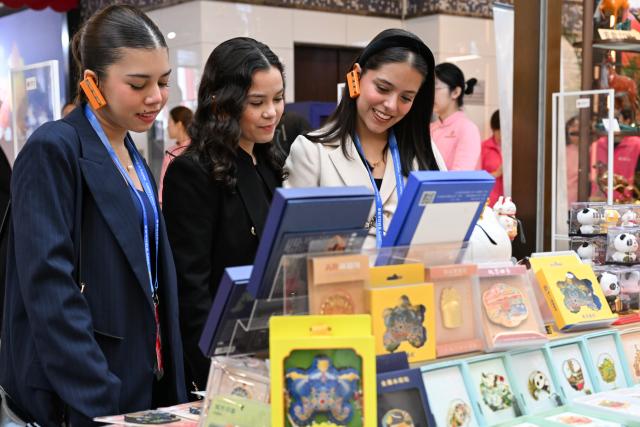 (251014) -- BEIJING, Oct. 14, 2025 (Xinhua) -- Representatives, who are in Beijing for the Global Leaders' Meeting on Women, learn about cultural and creative products while visiting the Silk Street building in Beijing, capital of China, Oct. 14, 2025. (Xinhua/Zou Jingyi)