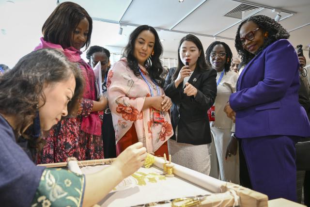 (251014) -- BEIJING, Oct. 14, 2025 (Xinhua) -- Representatives, who are in Beijing for the Global Leaders' Meeting on Women, learn about Beijing Embroidery while visiting the Silk Street building in Beijing, capital of China, Oct. 14, 2025. (Xinhua/Zou Jingyi)